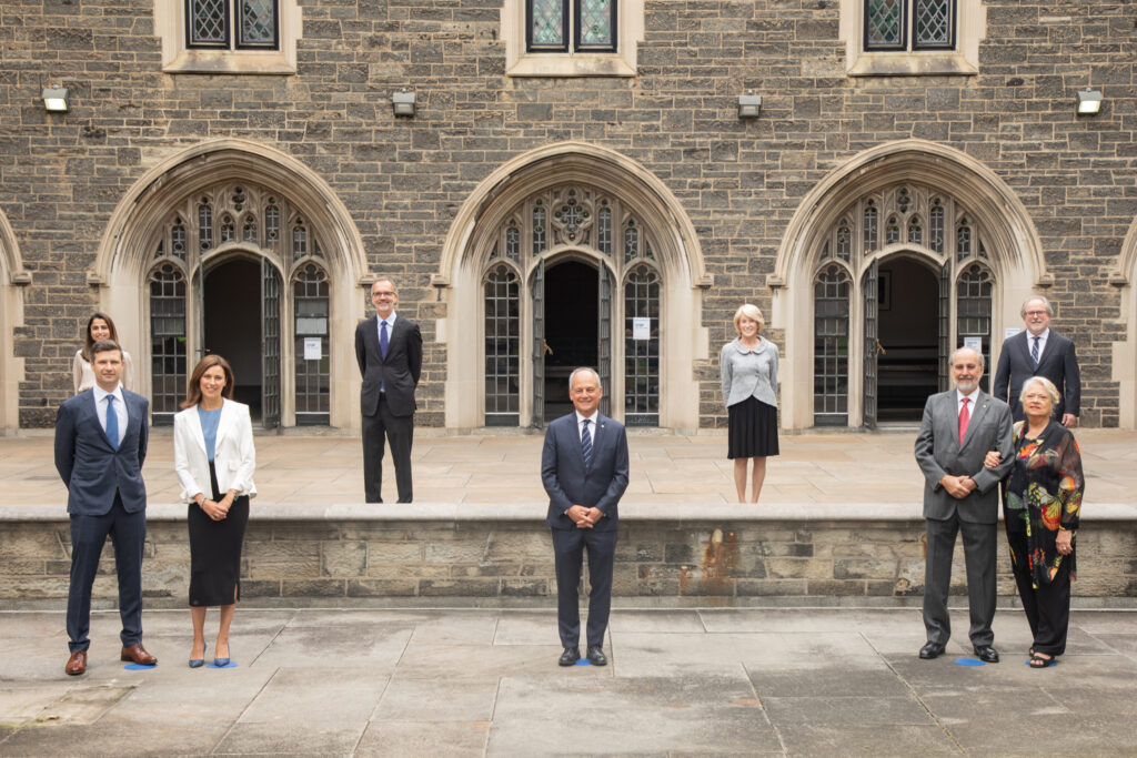 Standing at safe distances, standing in two rows outside of Hart House following the announcement of the Temerty Foundation’s historic gift to U of T Medicine. Back row (left to right): Hira Raheel, MD Candidate; Trevor Young, Dean, Temerty Faculty of Medicine; Rose Patten, Chancellor, U of T; David Palmer, Vice-President, Advancement, U of T; front row: Mike Lord; Leah Temerty-Lord; Meric Gertler, President, U of T; James Temerty; Louise Temerty.