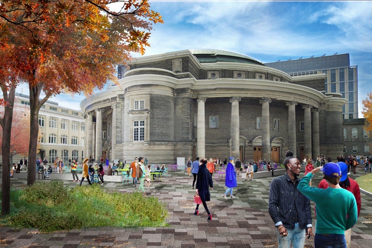 Chairs, tables, benches and trees are scattered across a granite-paved pedestrian area outside Convocation Hall.