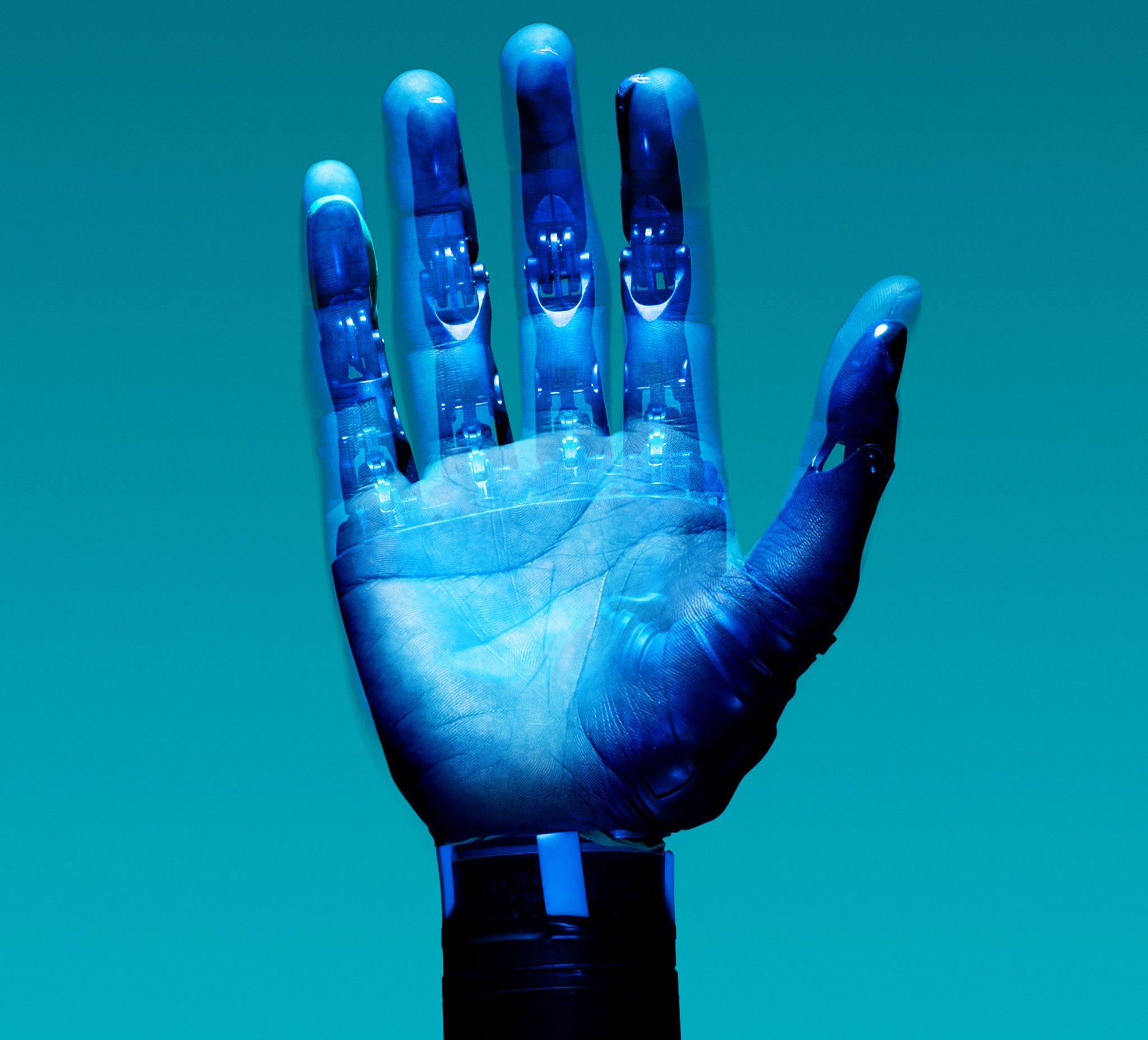 An image of a robotic hand superimposed on a real hand. It seems as if the robotic structure is inside a ghostly human hand.