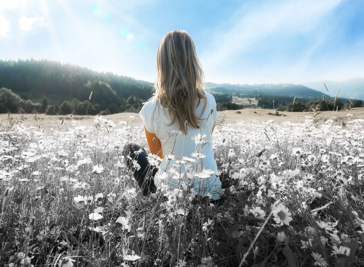 Woman looking at sky in a field of flowers