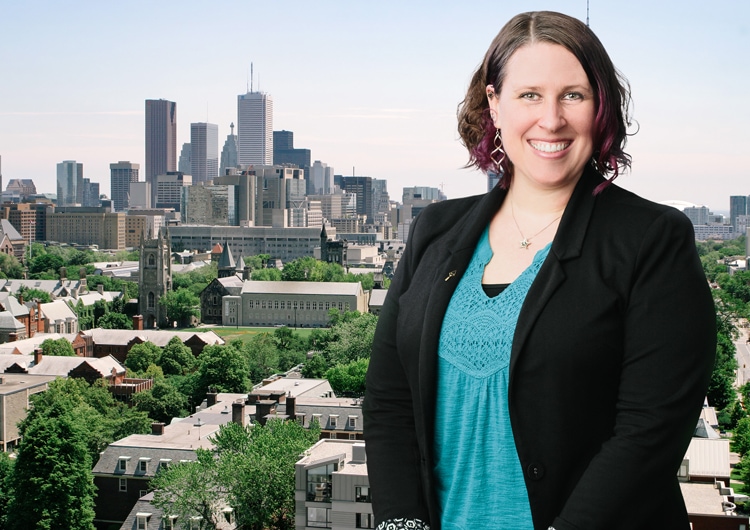 Photo of Tracy L. Spurrier smiling in front of the downtown Toronto skyline.