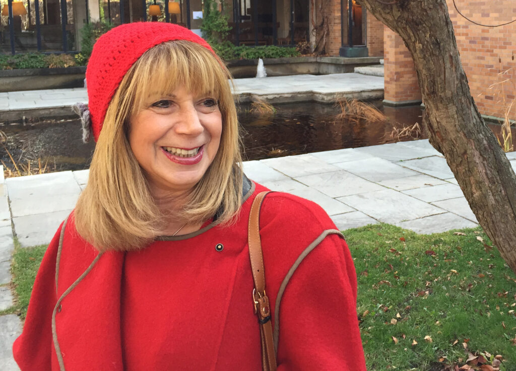 Esta Wall smiles as she stands by the small pond in front of U of T’s Massey College.