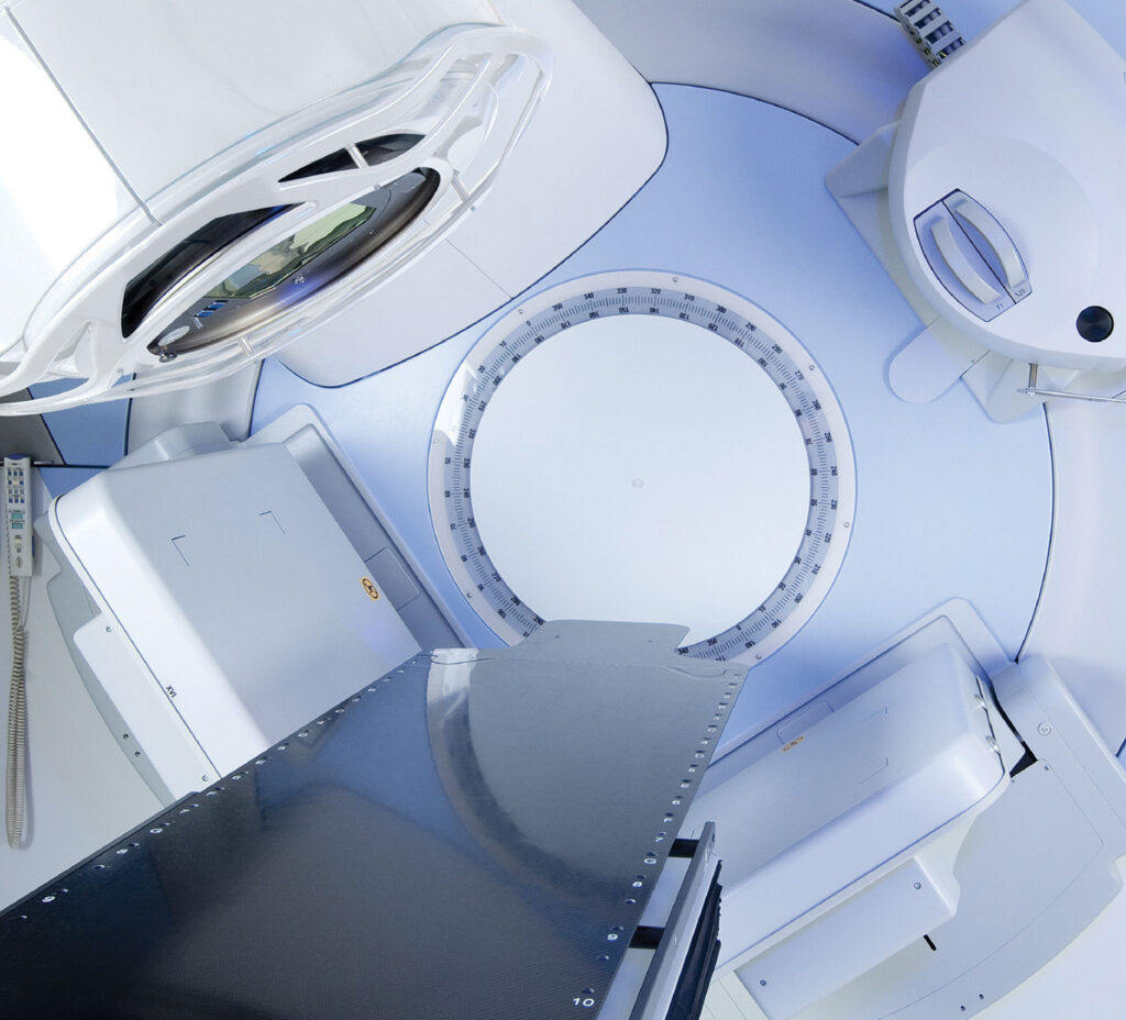 A machine to treat cancer with intensity-modulated radiation therapy: a flat bed surrounded by rotating equipment.