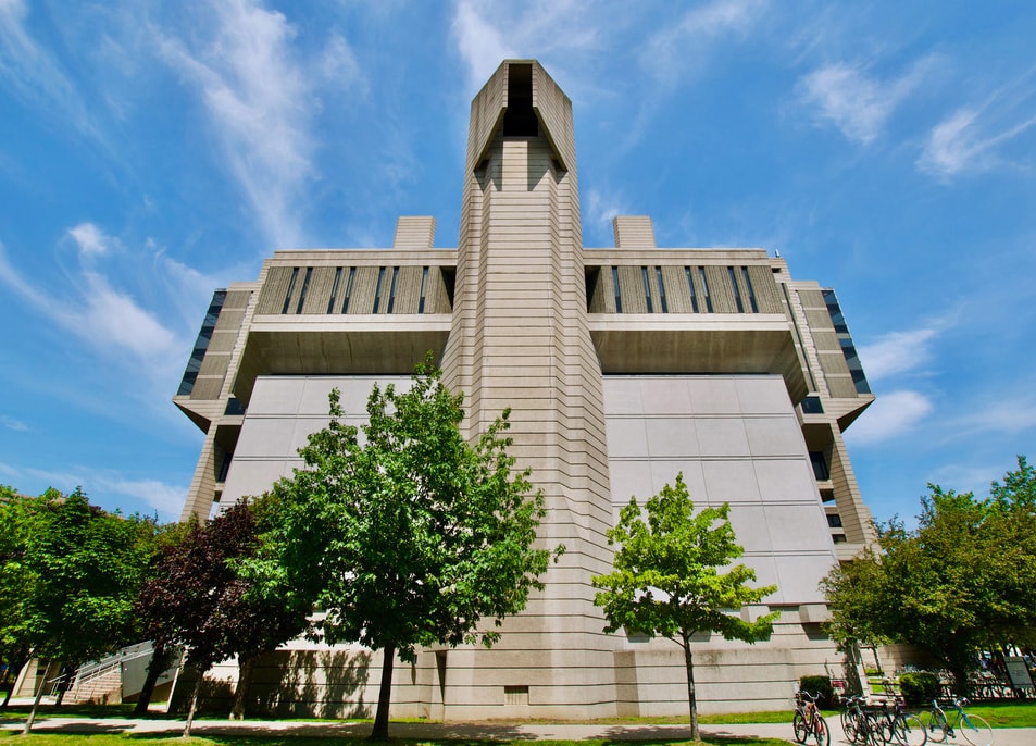The concrete facade of Robarts Library looms against a sunny sky in summer.