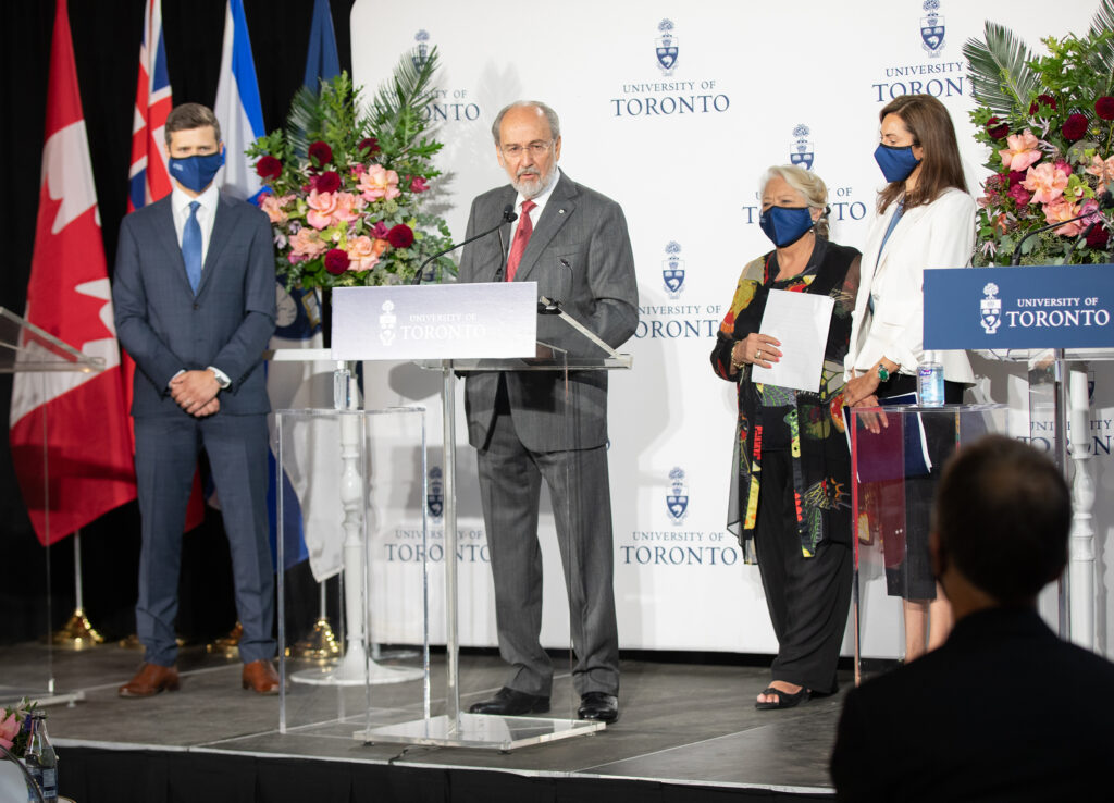 James Temerty speaks at a podium with the University of Toronto logo.