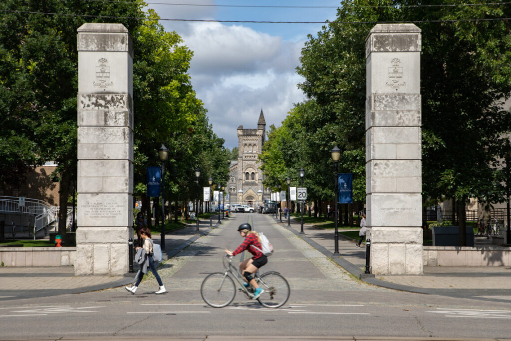 A cyclist whizzes past two stone pillars flanking the College Street entrance to King’s College Road.