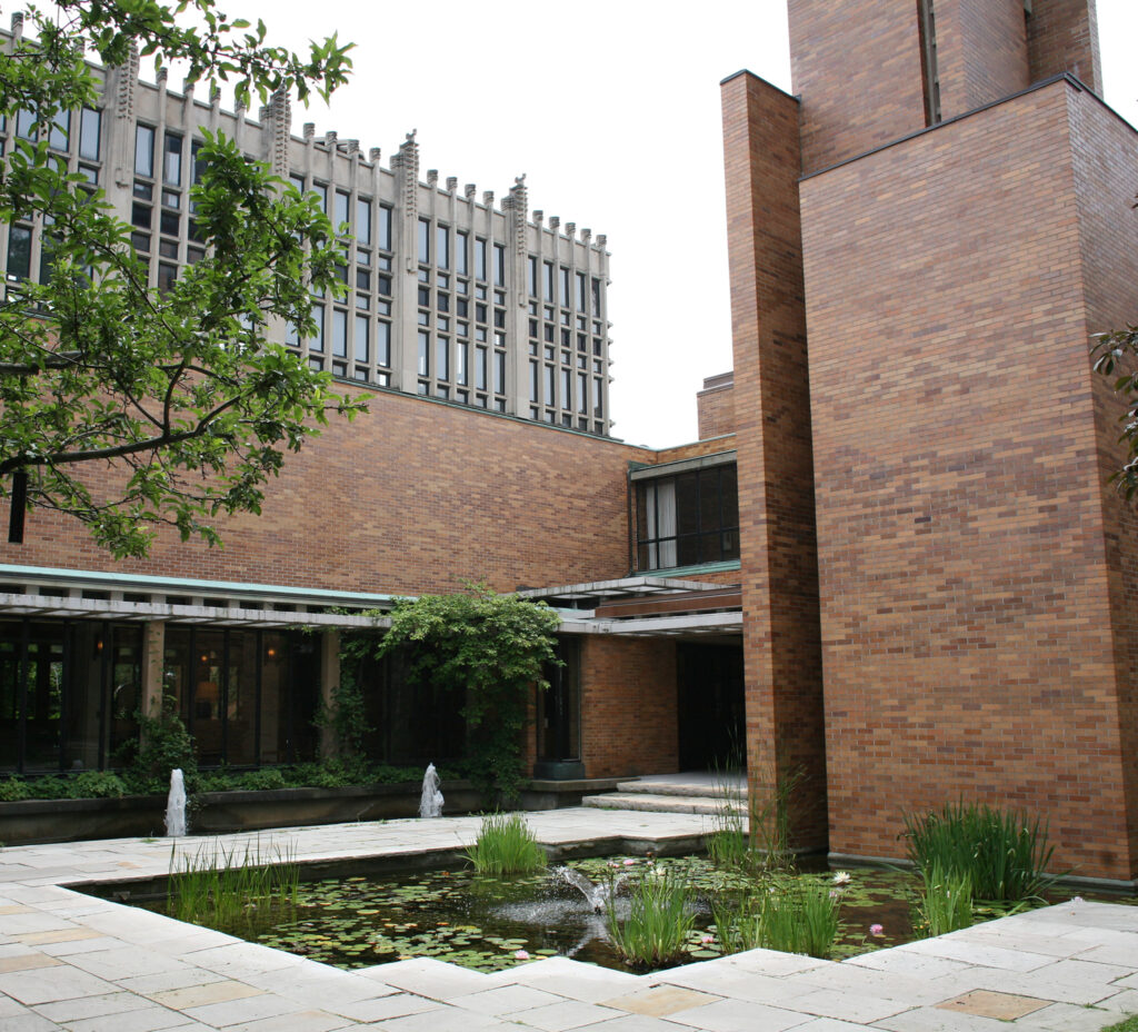 In the courtyard of Massey College, paving surrounds a quiet pond with water plants and a tiny fountain.