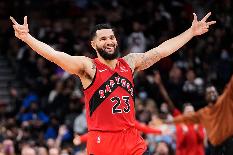 Fred VanVleet, wearing his Toronto Raptors uniform, lifts his arms in celebration, during a basketball game.