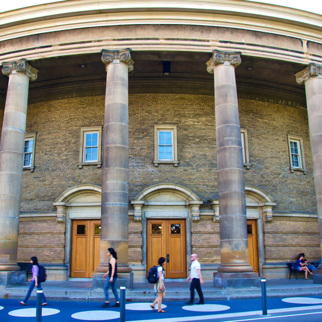 Students walk past the pillars in front of Convocation Hall.