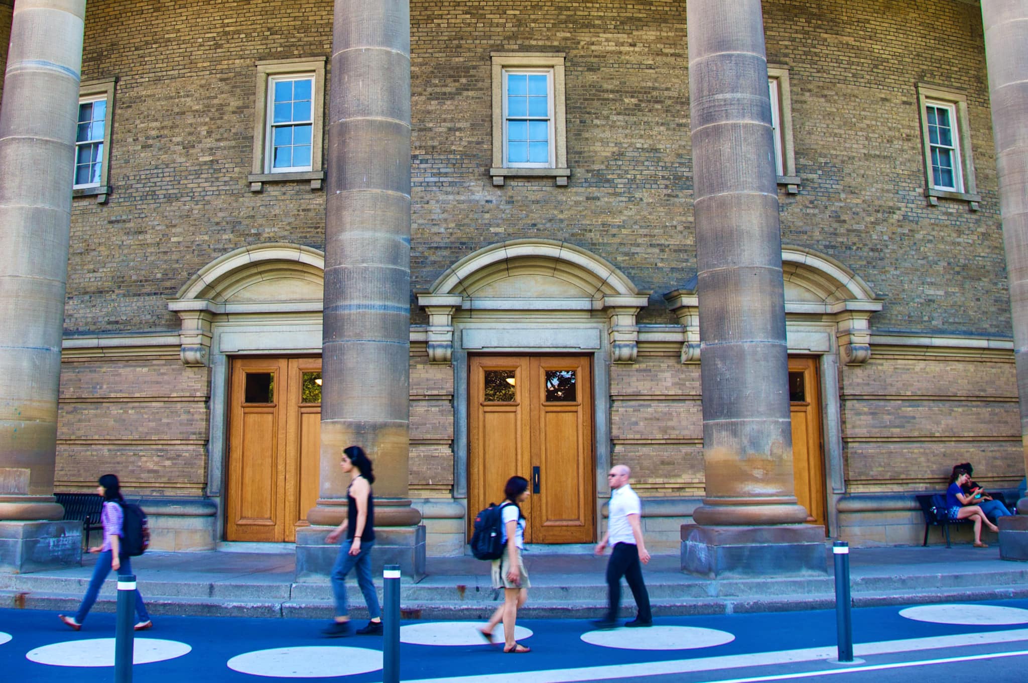 Students walk past the pillars in front of Convocation Hall.