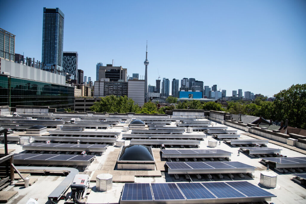 Solar panels cover the roof of 255 McCaul Street, looking over downtown Toronto and the CN Tower.