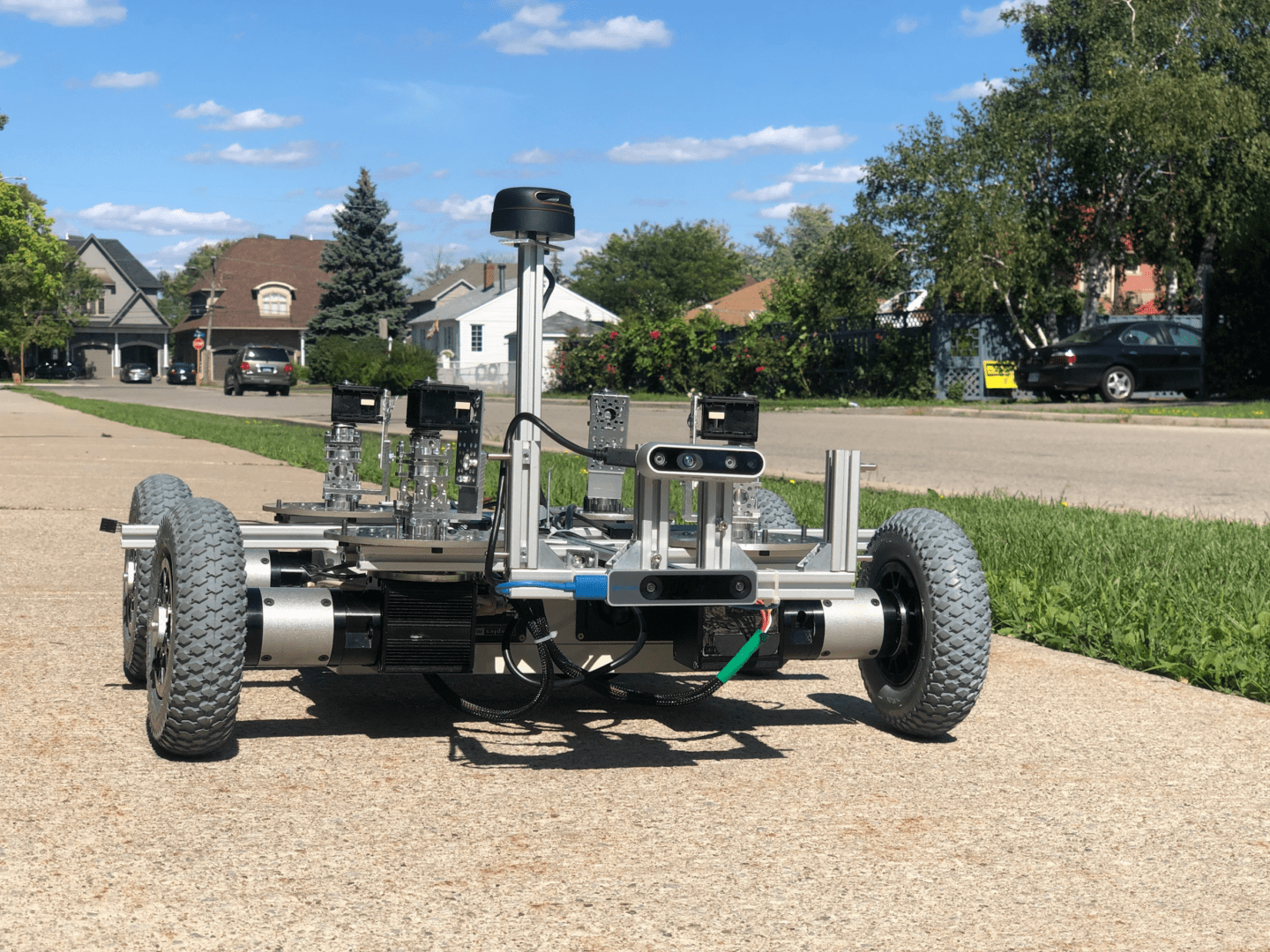 The Blip delivery robot is a wheeled, robotic-looking platform, half the width of a sidewalk.