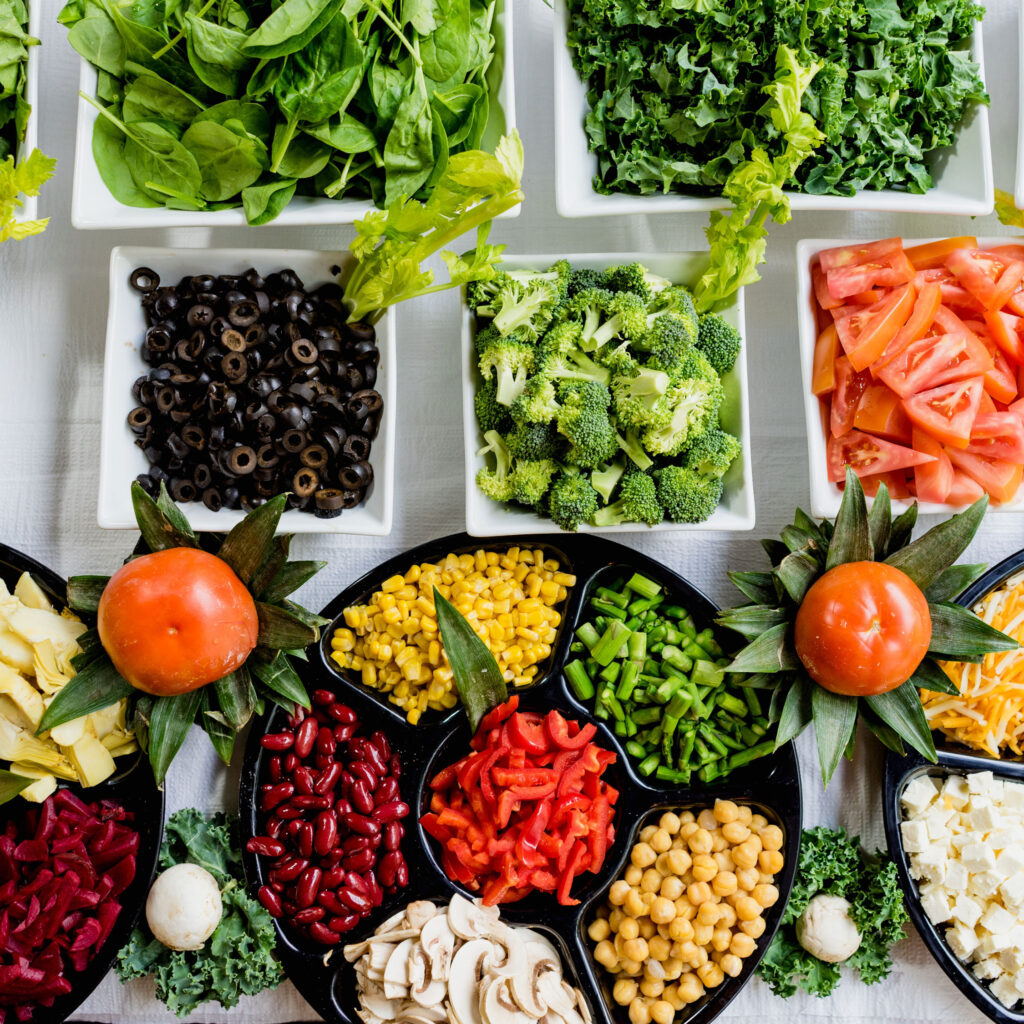 An array of dozens of fresh chopped vegetables, each in a different bowl.