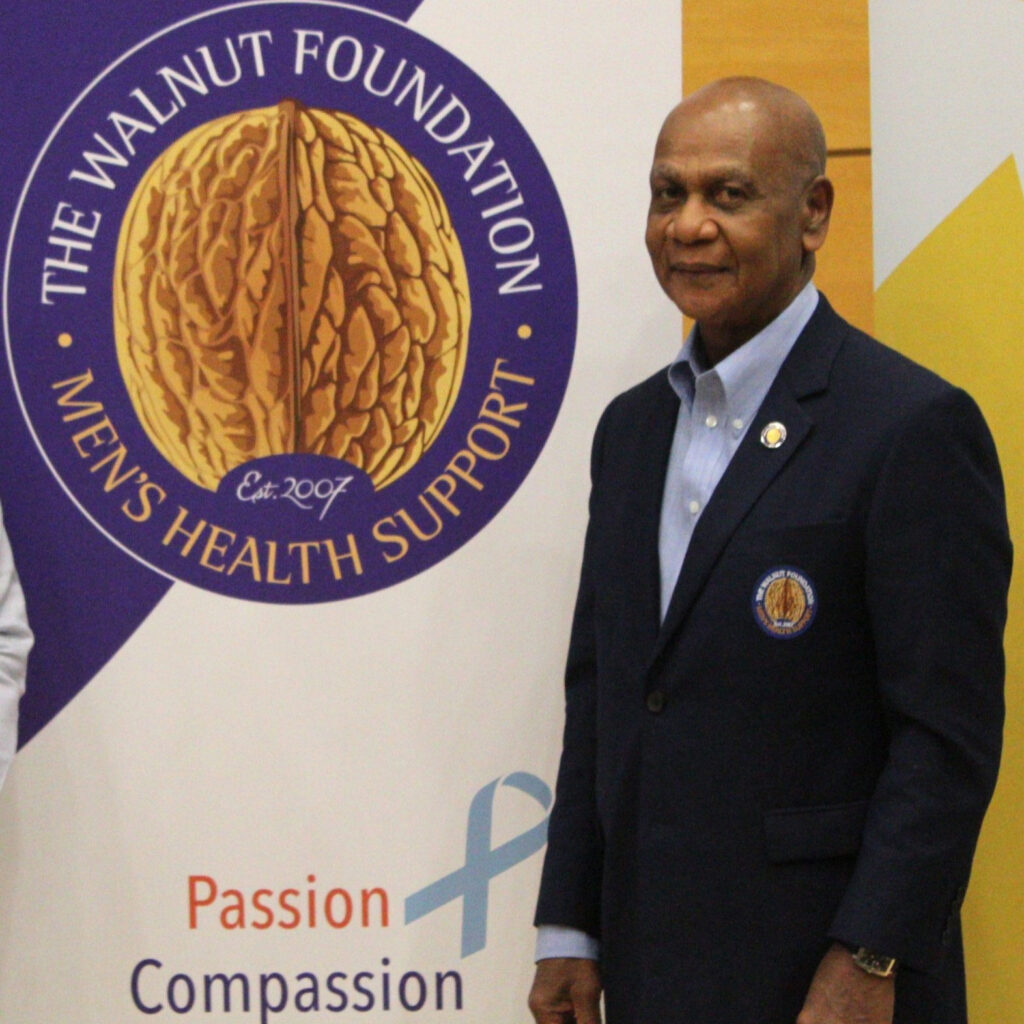 Winston Isaac stands next to a logo of a walnut. Text reads: Walnut Foundation, men's health support.