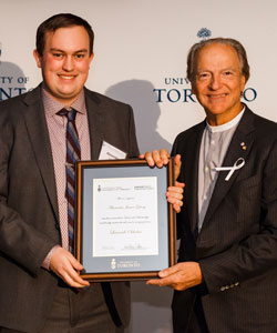 Pierre Lassonde presents Alec Gilvesy with a framed award.