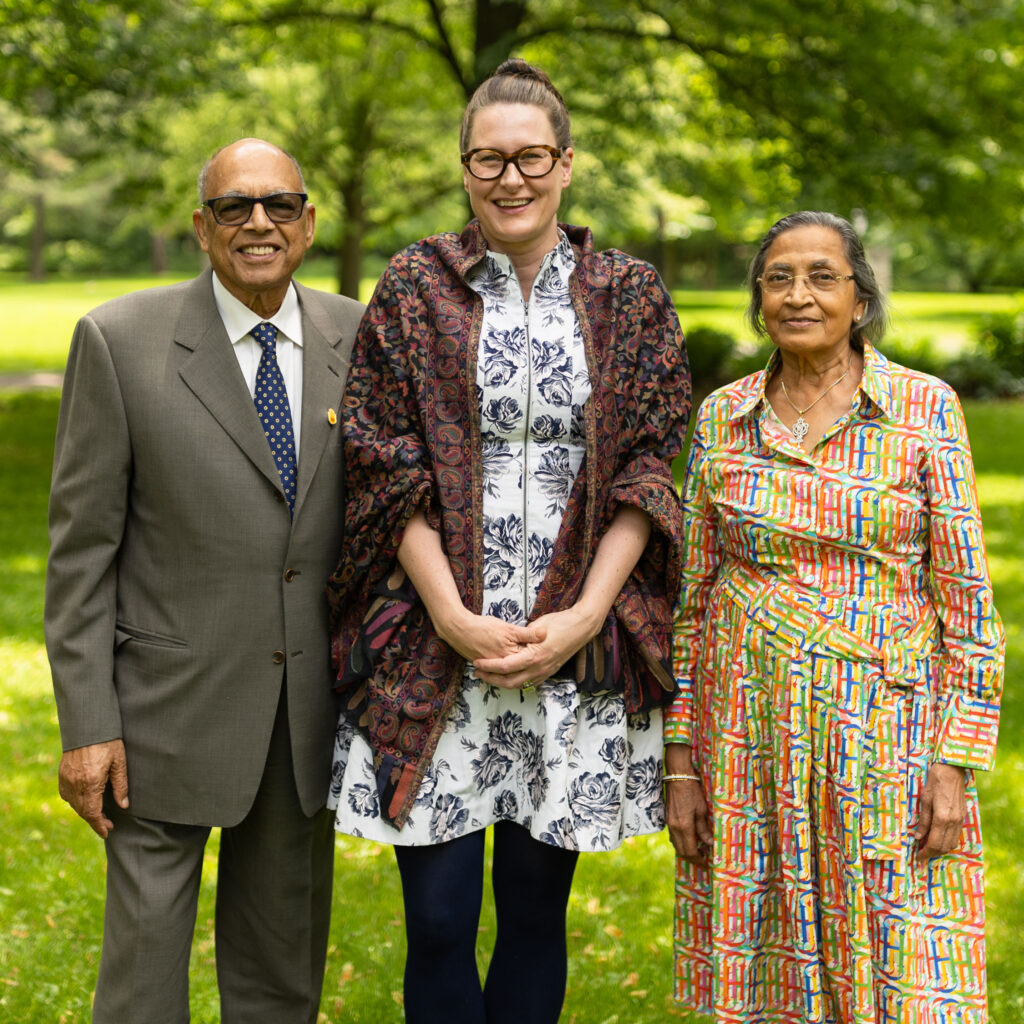 Gyan Jain, Alexandra Gillespie and Kanchan Jain stand in a park, smiling.