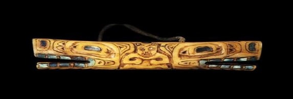 A small stick carved with a wolf head on each end in the art style of West Coast First Nations.
