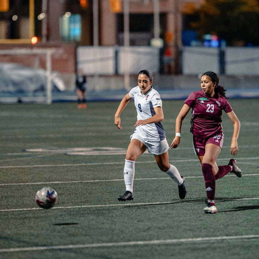 Yasmeen Al-Kas races an opposing player to reach a soccer ball.