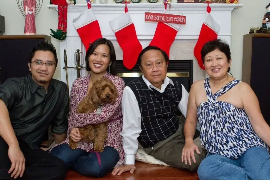 Christopher, Cherrie, and their parents Alex and Alicia Chiu sit together in front of fireplace.