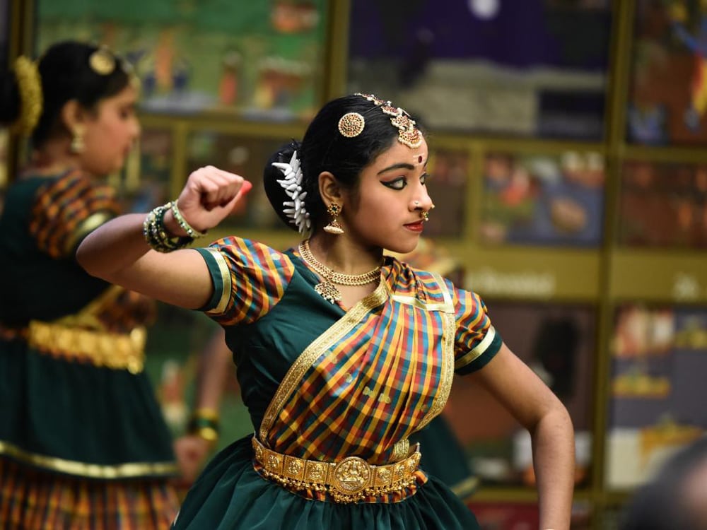 Tamil woman in traditional dress dances.