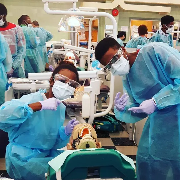 Two students wearing medical gowns and masks