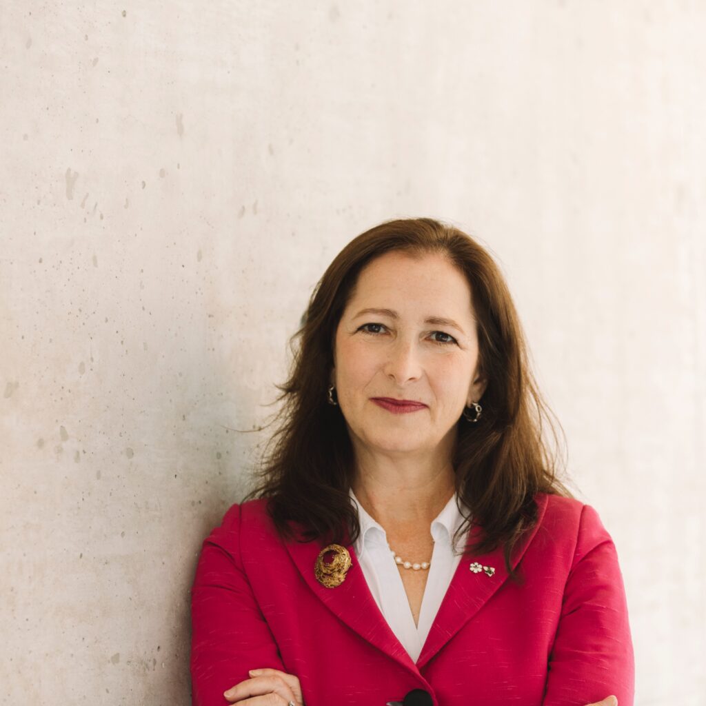 Portait of Molly Shoichet wearing a bright fuchsia blazer