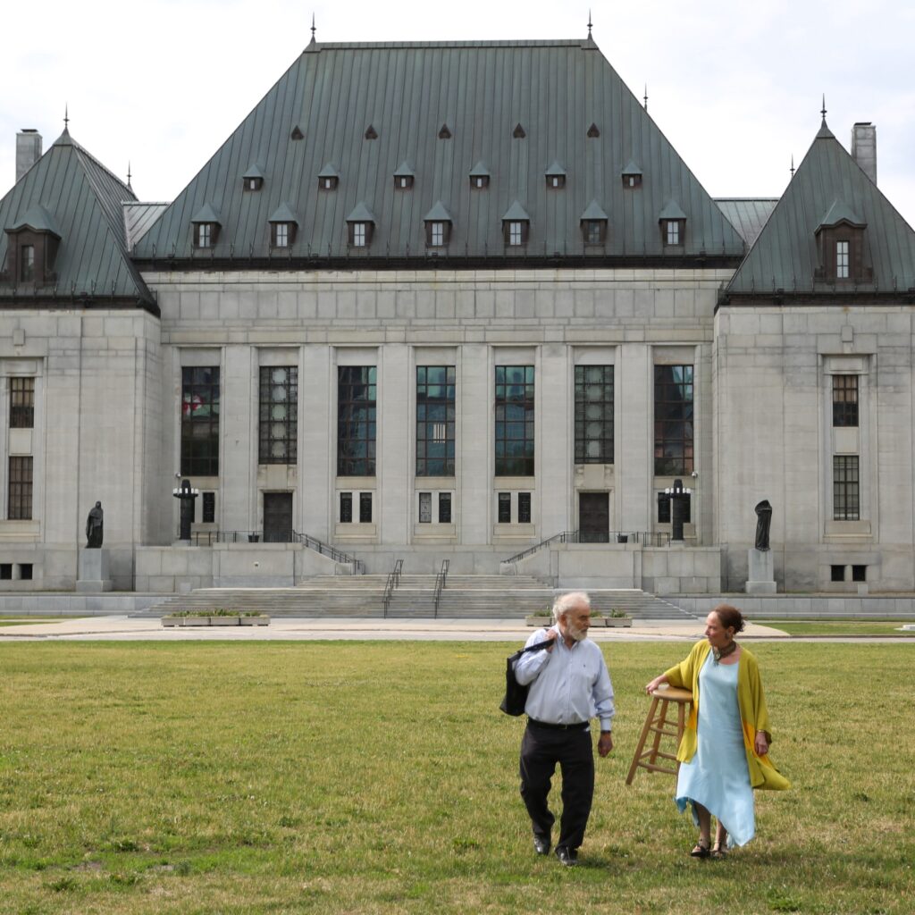 Two people in front of a courthouse. 