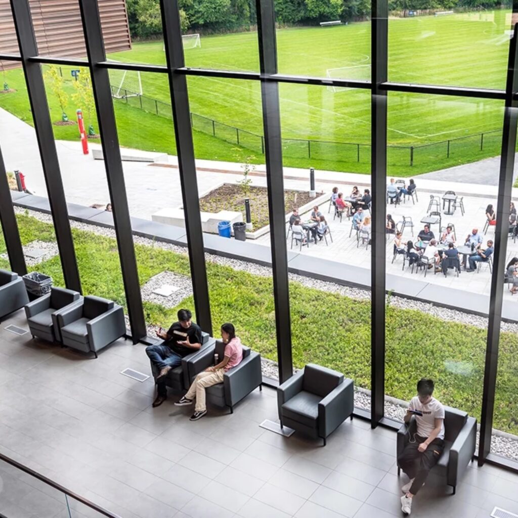 Students in a lounge area next to a bit window