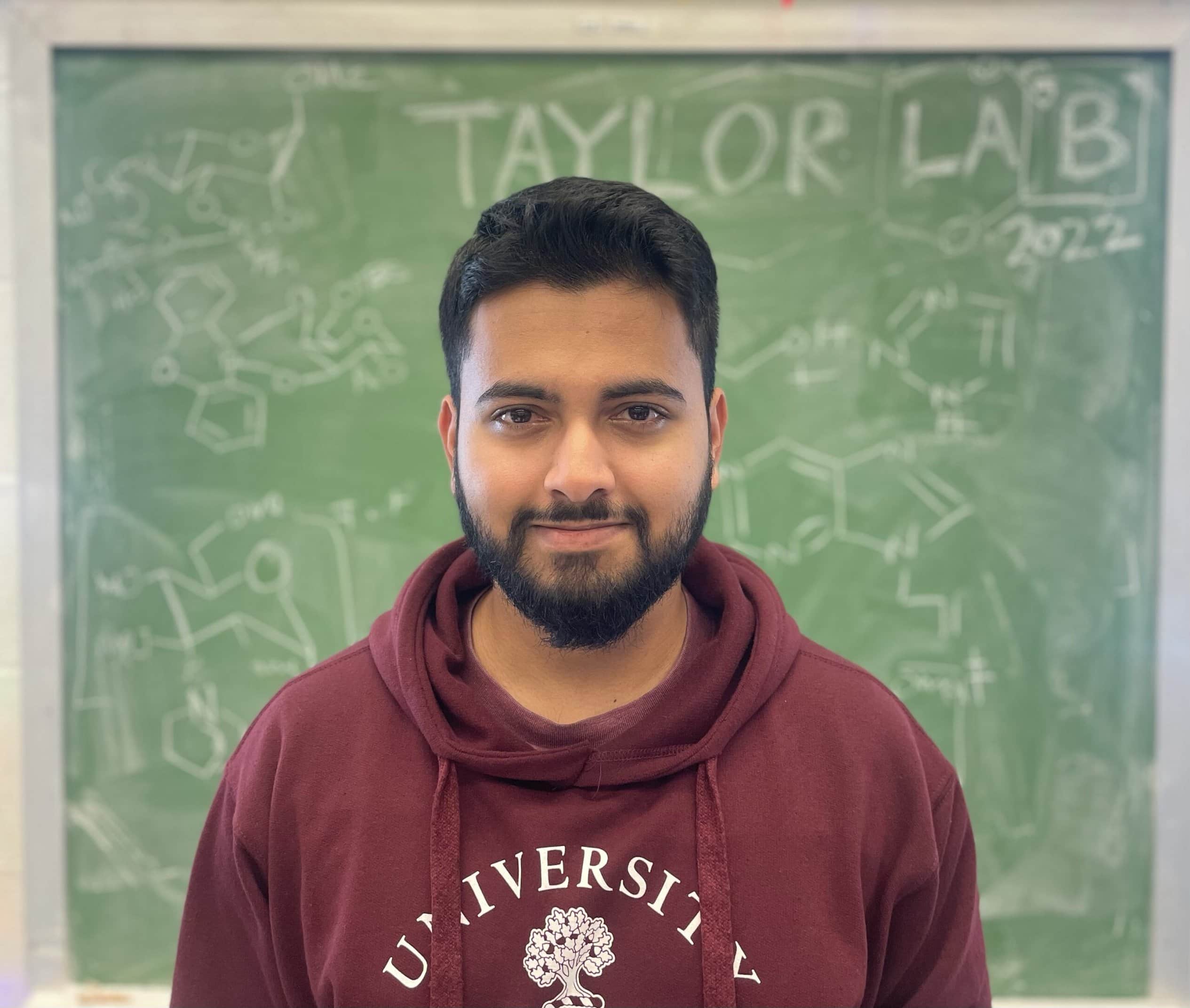 Portrait of Shrey in front of a green chalkboard