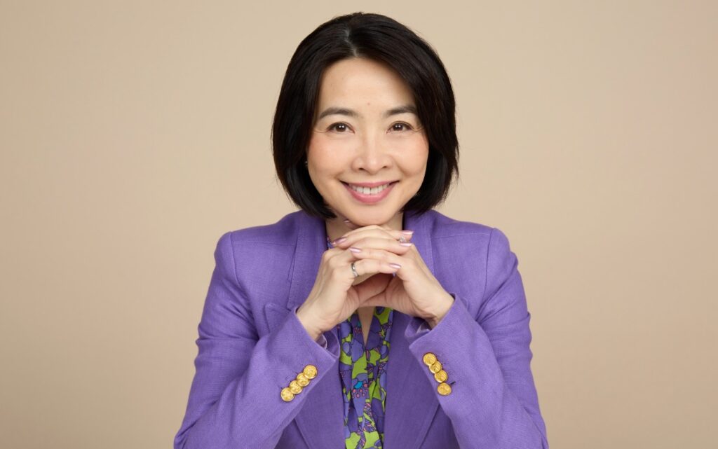 Eva Lau smiling and wearing a purple blazer