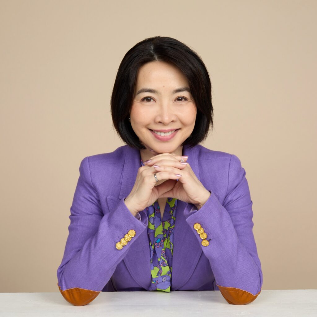 Portrait of Eva Lau smiling and wearing a purple blazer