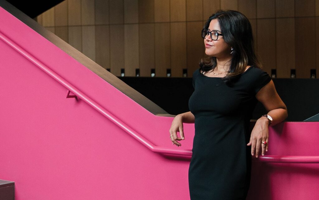 Bidisha posing by a pink staircase