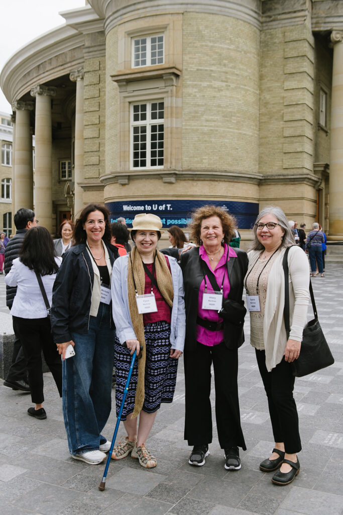 Photo of four attendees smiling together.