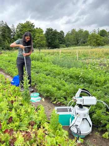 A woman using high-tech equipment in a vegetable garden