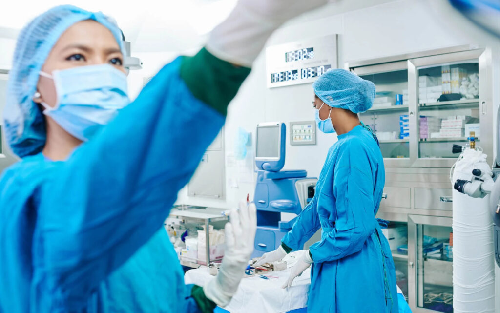 Two researchers wearing medical garb in a lab