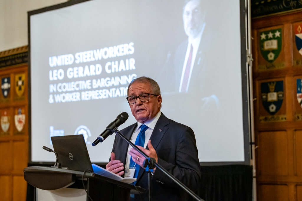 Ken Neumann speaking at a podium. 