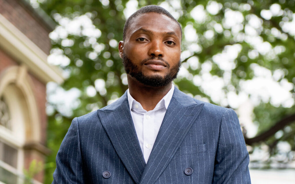 A portrait of Mathew Okwoli standing outdoors.