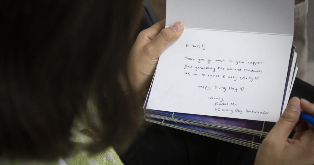 Close-up photo of Giving Day Ambassador, Rachel Ma's hands holding a Thank You card with a message of thanks