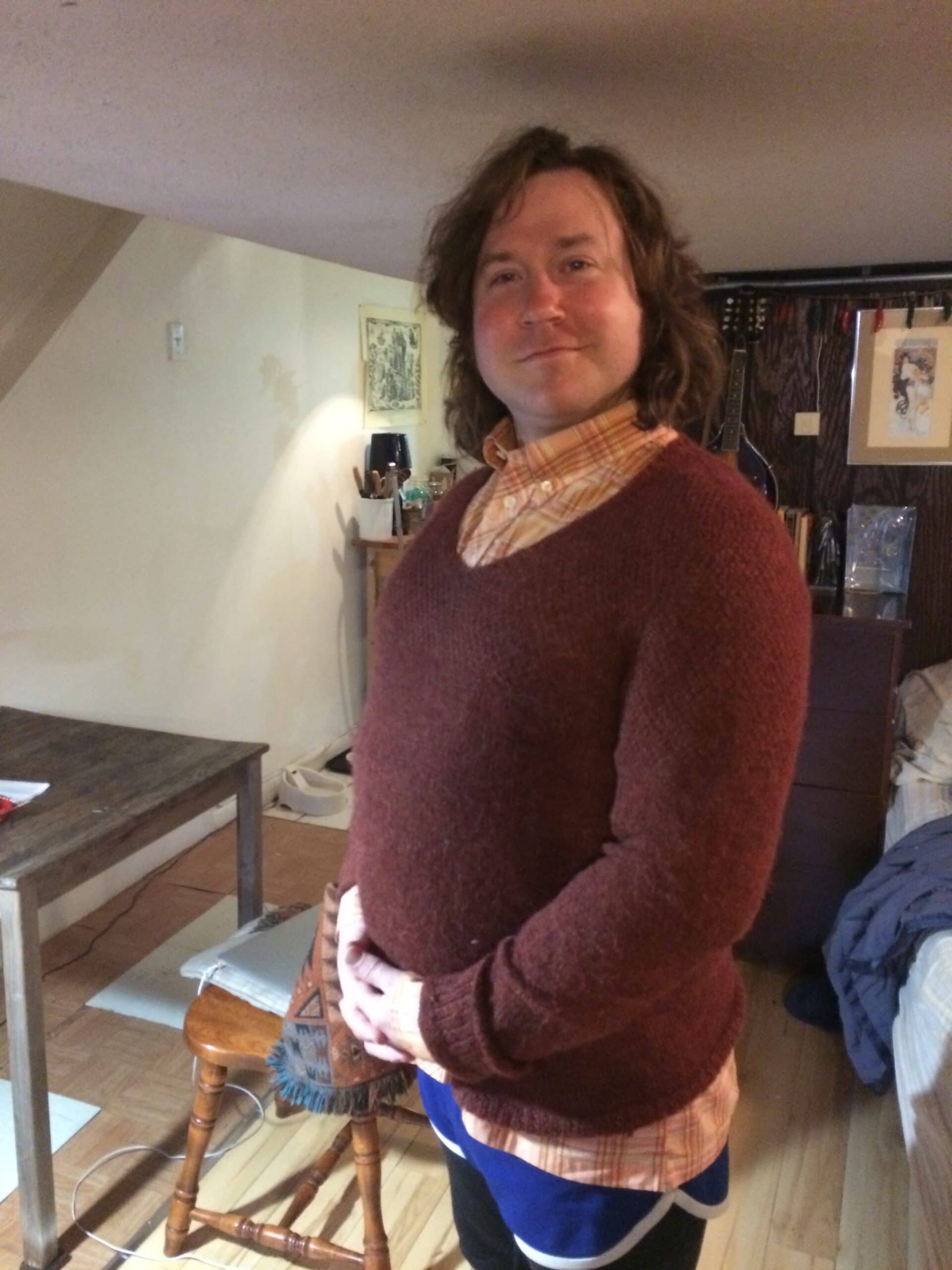 Martin standing and smiling in a maroon sweater.