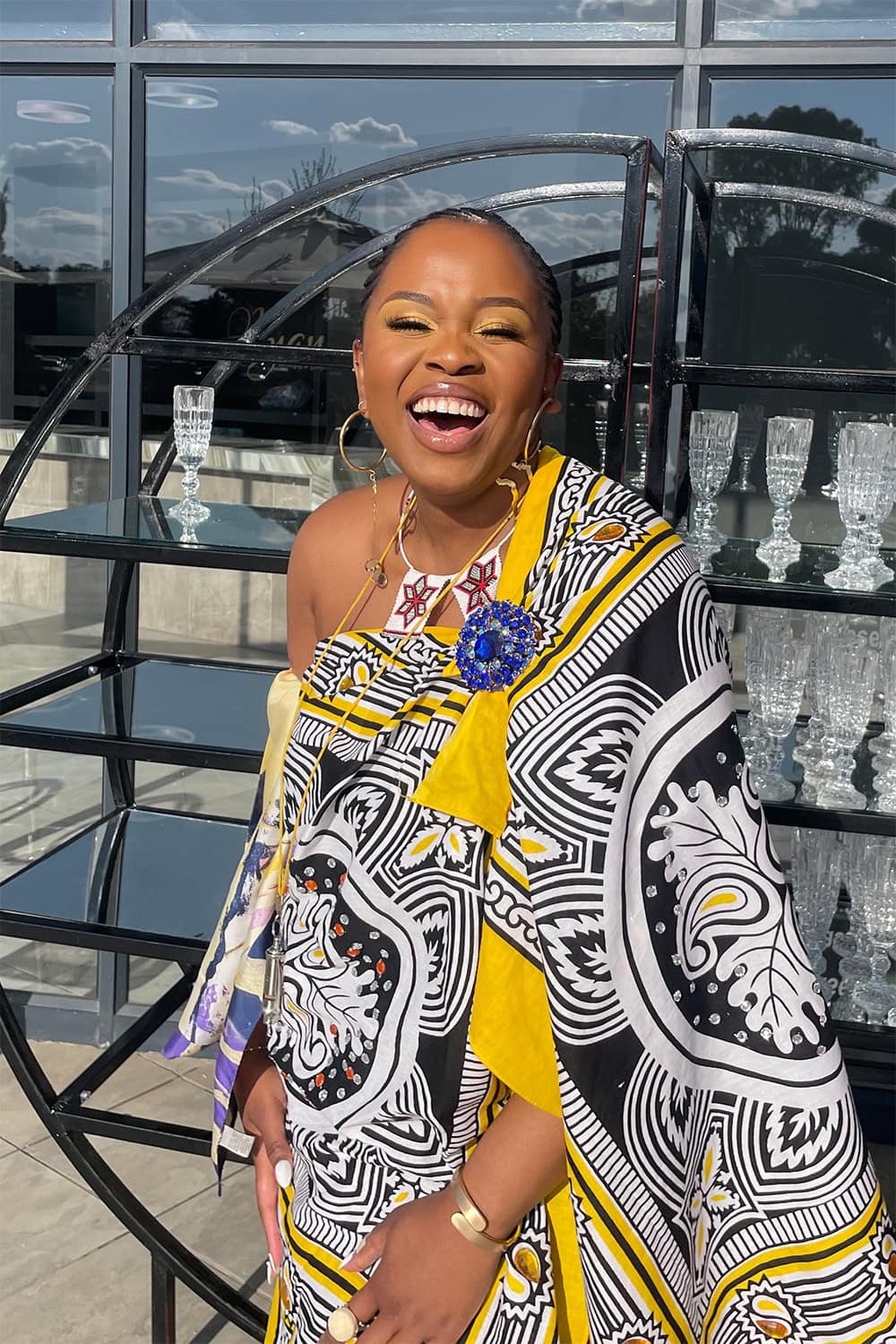 A person smiling in a bright, patterned outfit