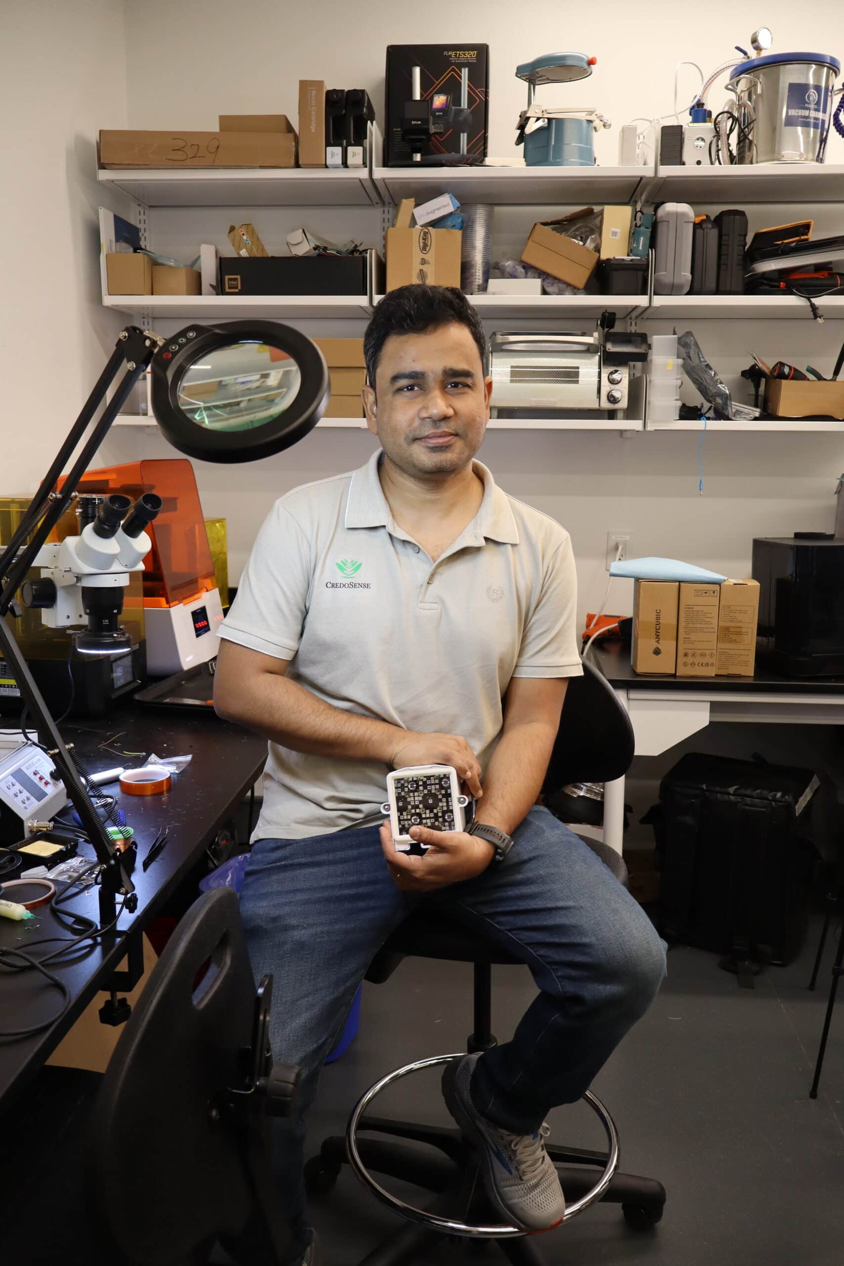 A person sitting and holding a piece of equipment