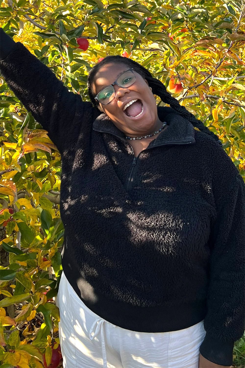 A person smiling with one arm stretched into the air.