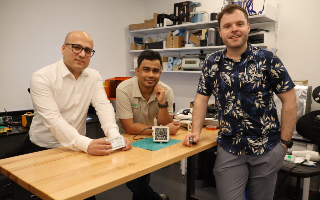 Three people standing around a table