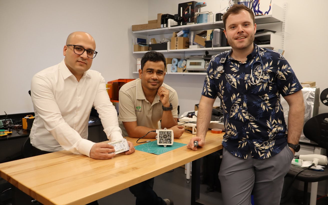 Three people standing around a table