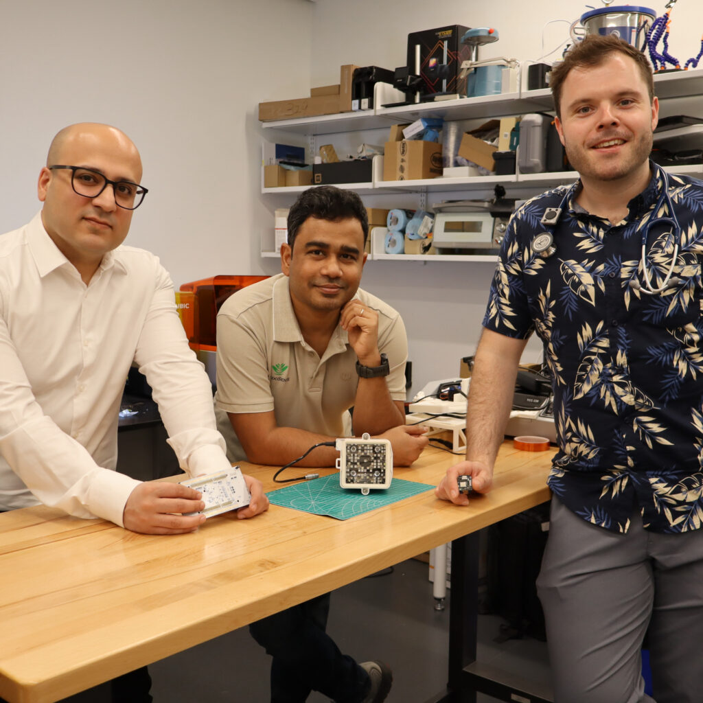 Three people standing around a table